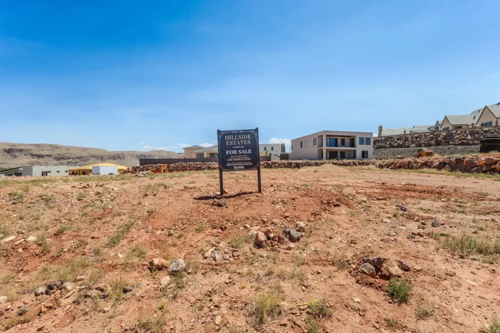 Expansive land parcel with surrounding residential development and distant mesa formations