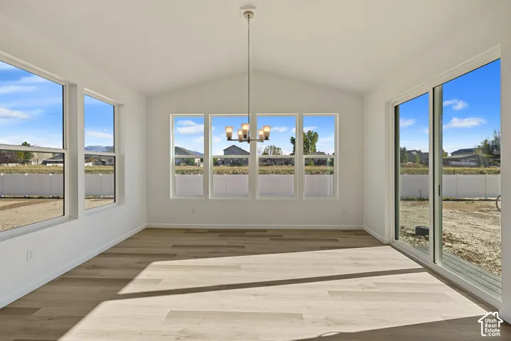 Right next to the kitchen is an oversized dining space (Sunroom) with vaulted ceiling and a pendant light. The room is surrounded by windows bringing in lots of natural light with a sliding glass door leading out to the large yard.