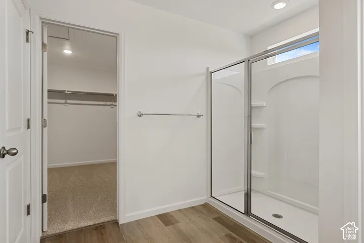 Oversized Walk-in shower with integrated shelving, glass enclosure, and transom window sits across from the vanity with PLENTY of space in-between.