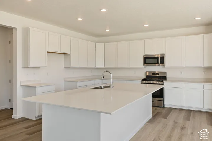 Large beautiful kitchen with an oversized island, soft close cabinets and drawers. a walk-in pantry sits just right off to the side near the garage entrance.