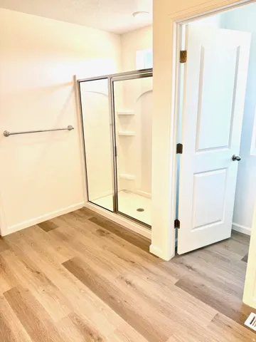 Shower enclosure with glass door, separate toilet room.