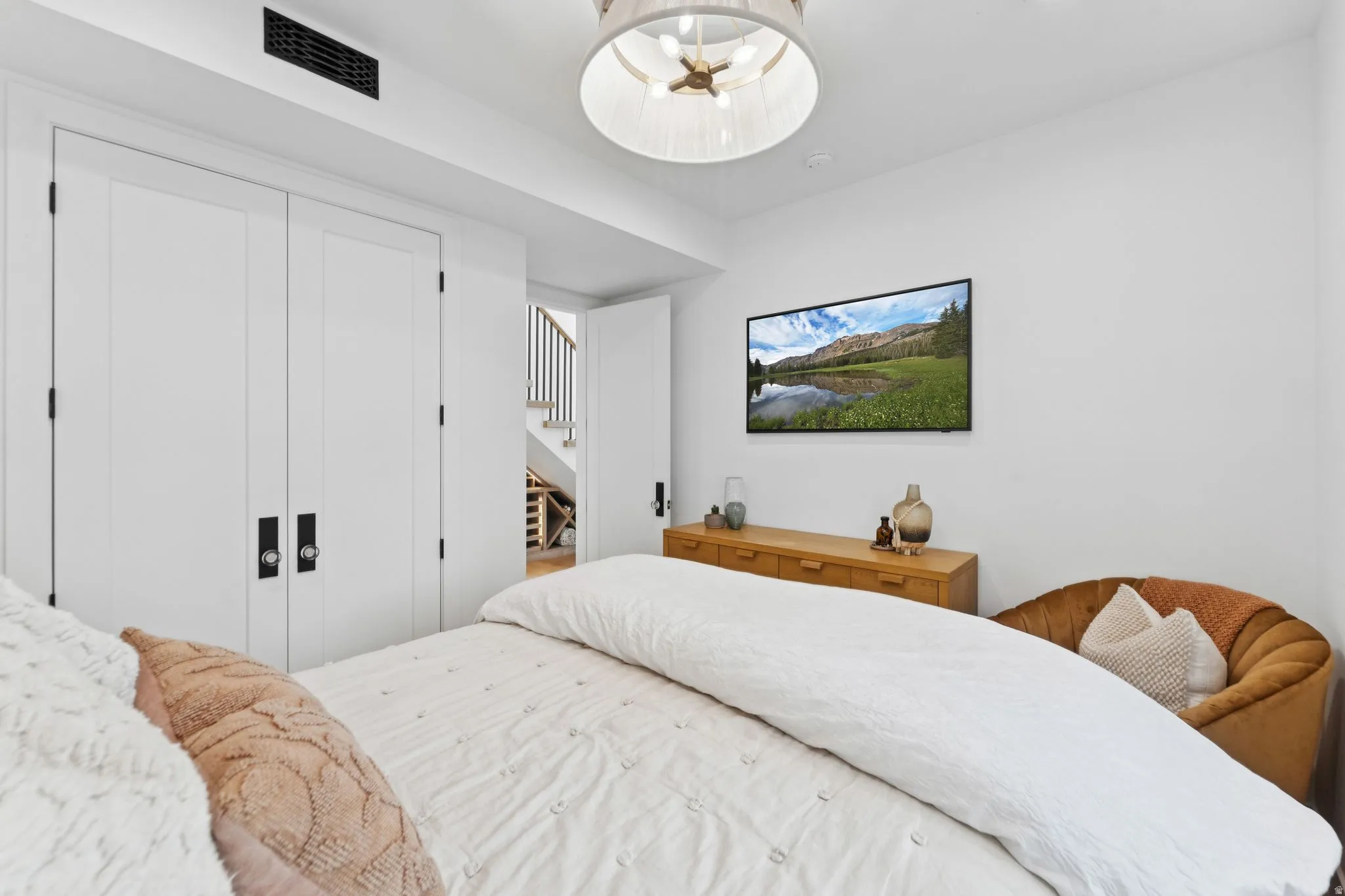 Recessed ceiling vent and a contemporary drum chandelier illuminate the space