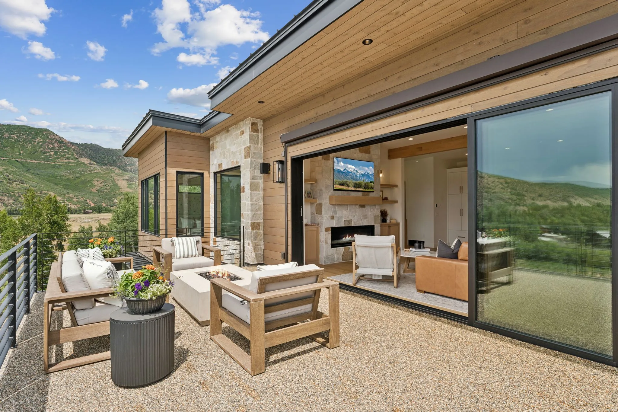 Expansive outdoor deck featuring exposed aggregate flooring and a built-in fire pit
