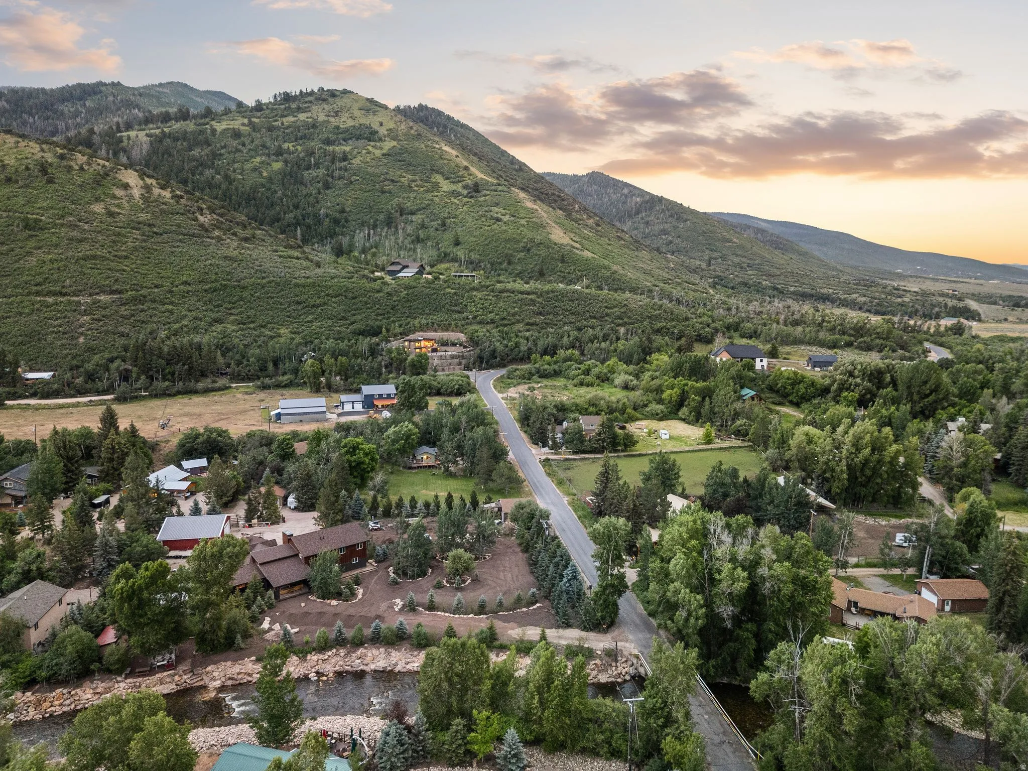 Aerial perspective showcasing verdant mountains, a winding river, and a network of roads