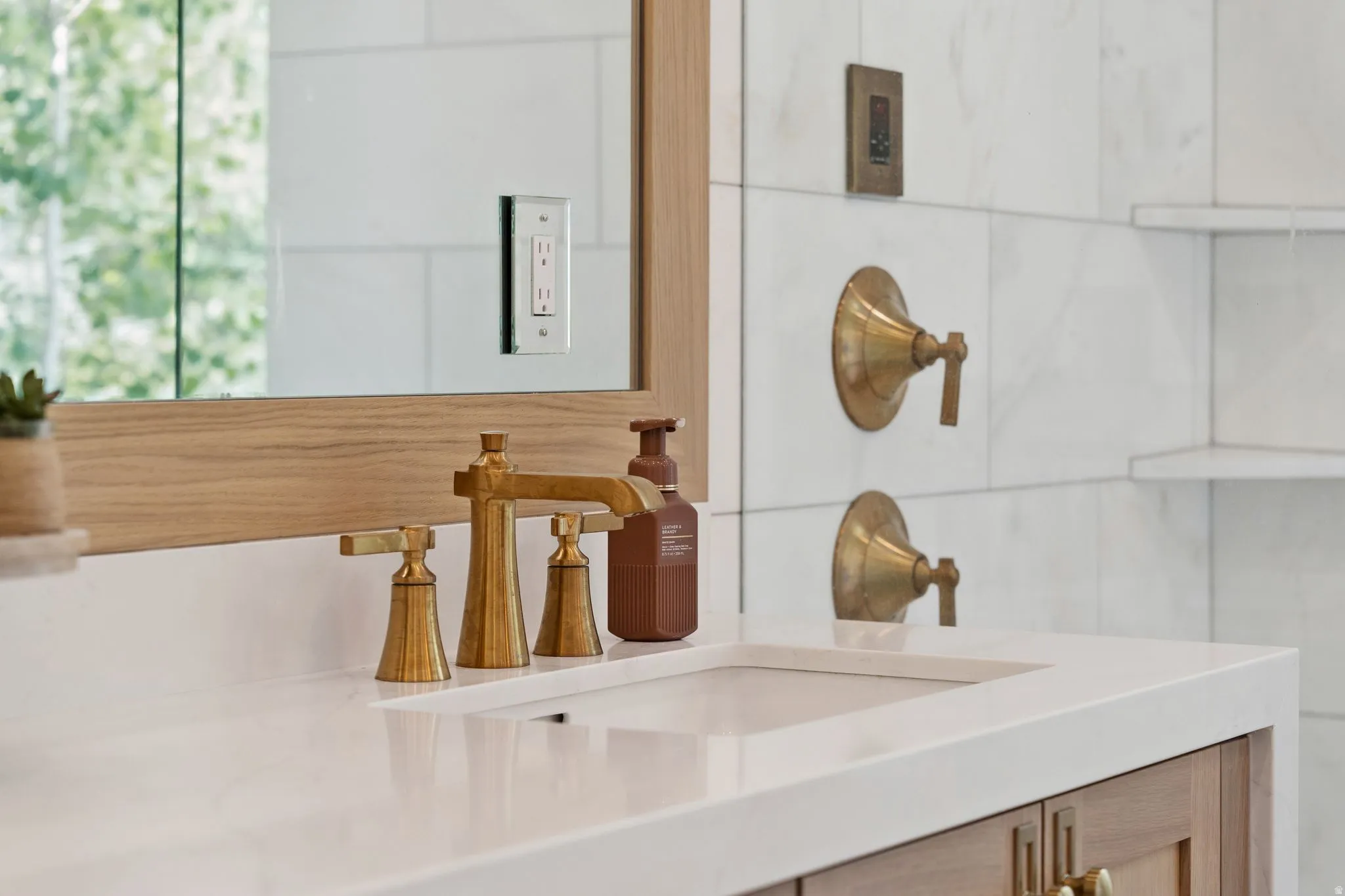 Vanity featuring a white countertop with an undermount sink and brass-finish faucet