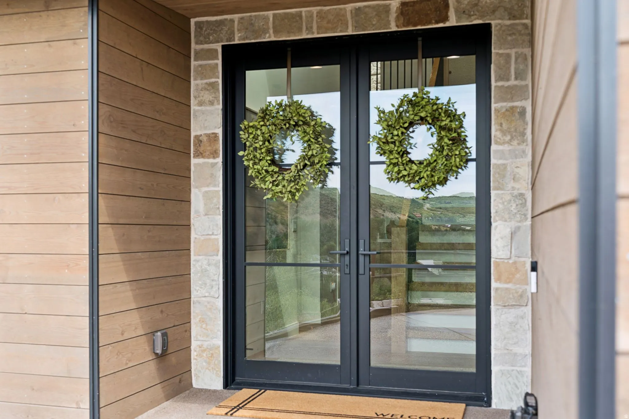 Double-door entry featuring a black metal frame and clear glass panels