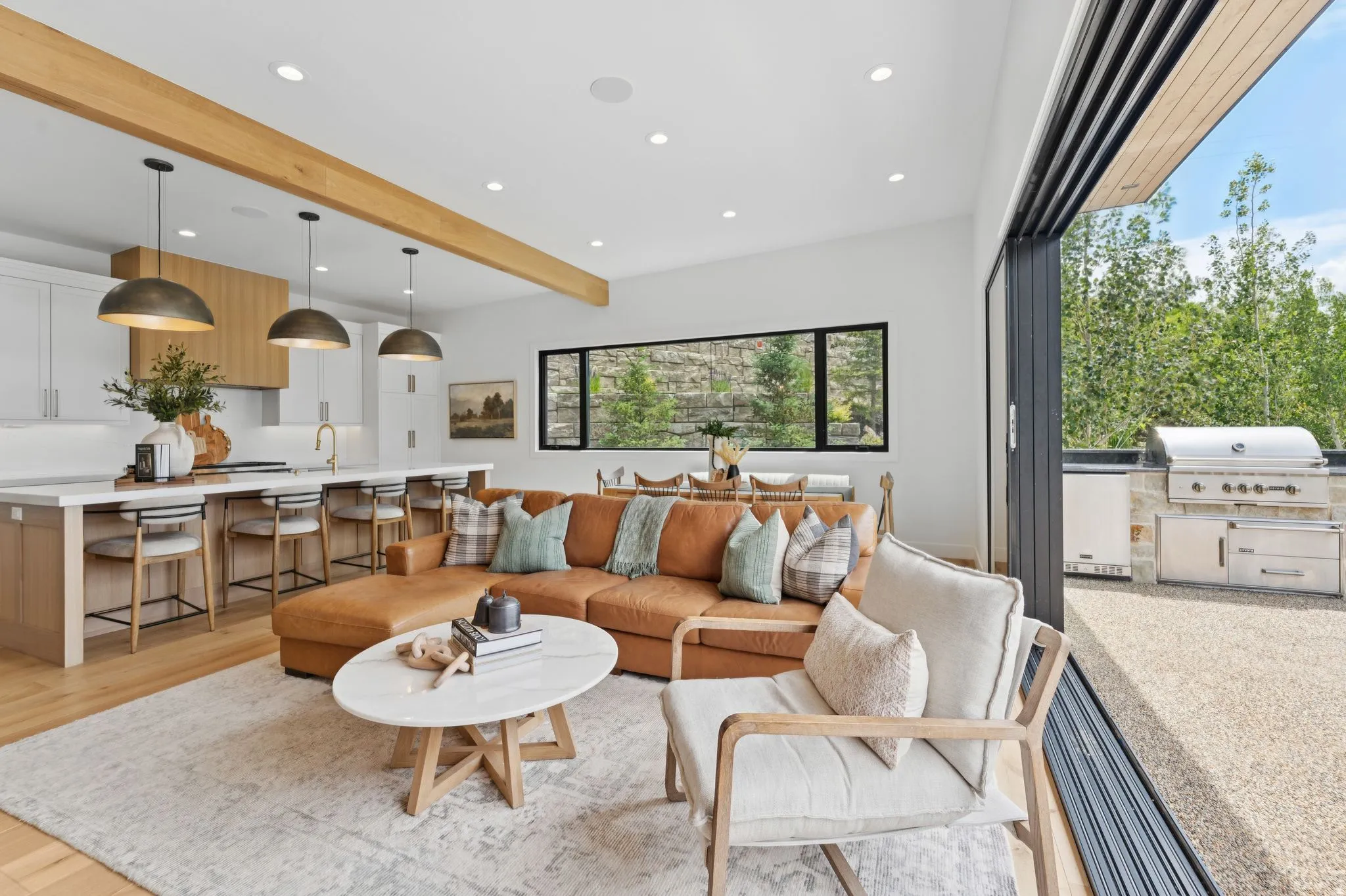 Open-concept living area featuring wood-finish flooring, recessed lighting, and exposed ceiling beams