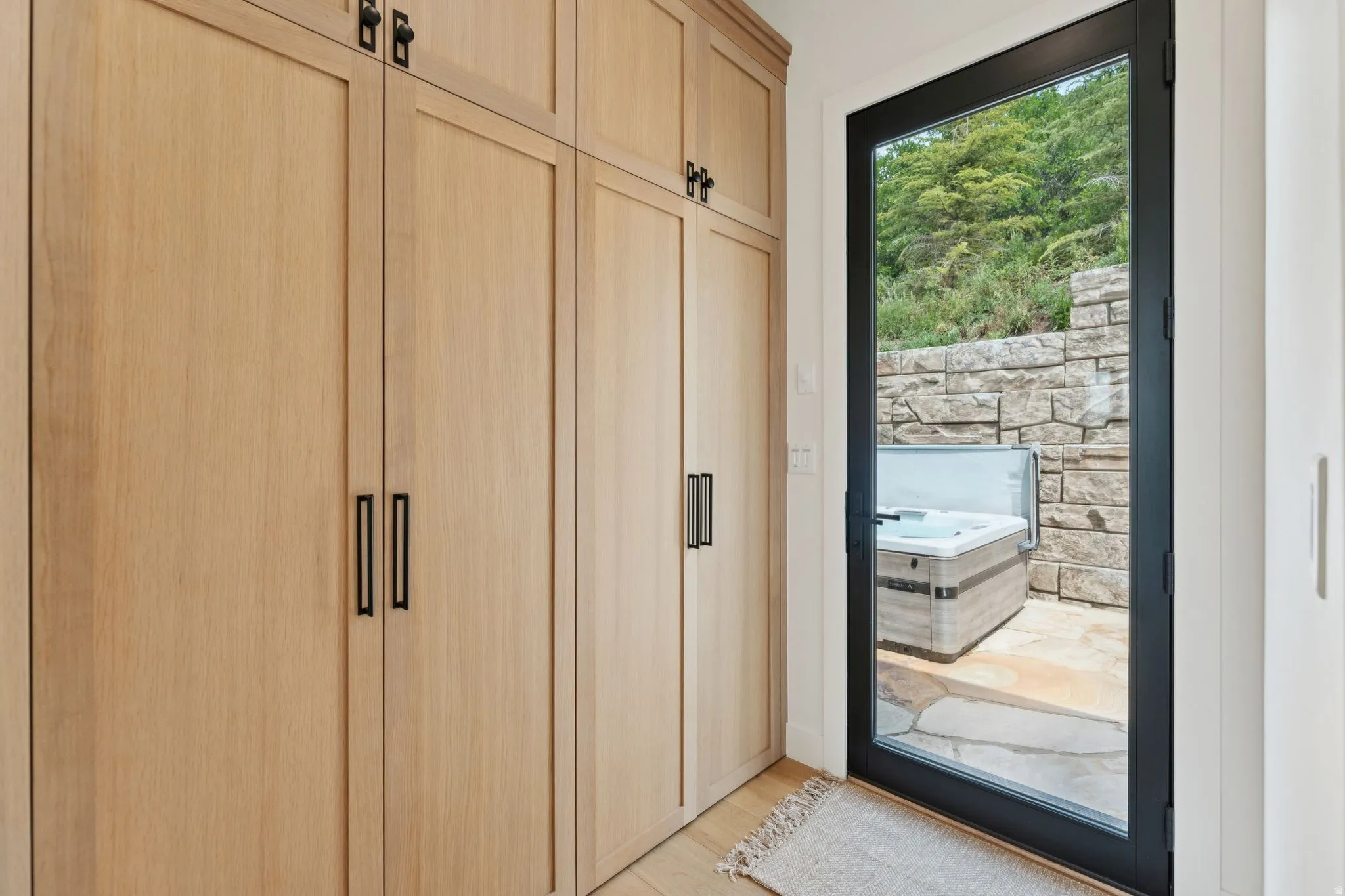Built-in wood-finish cabinetry featuring matte black hardware
