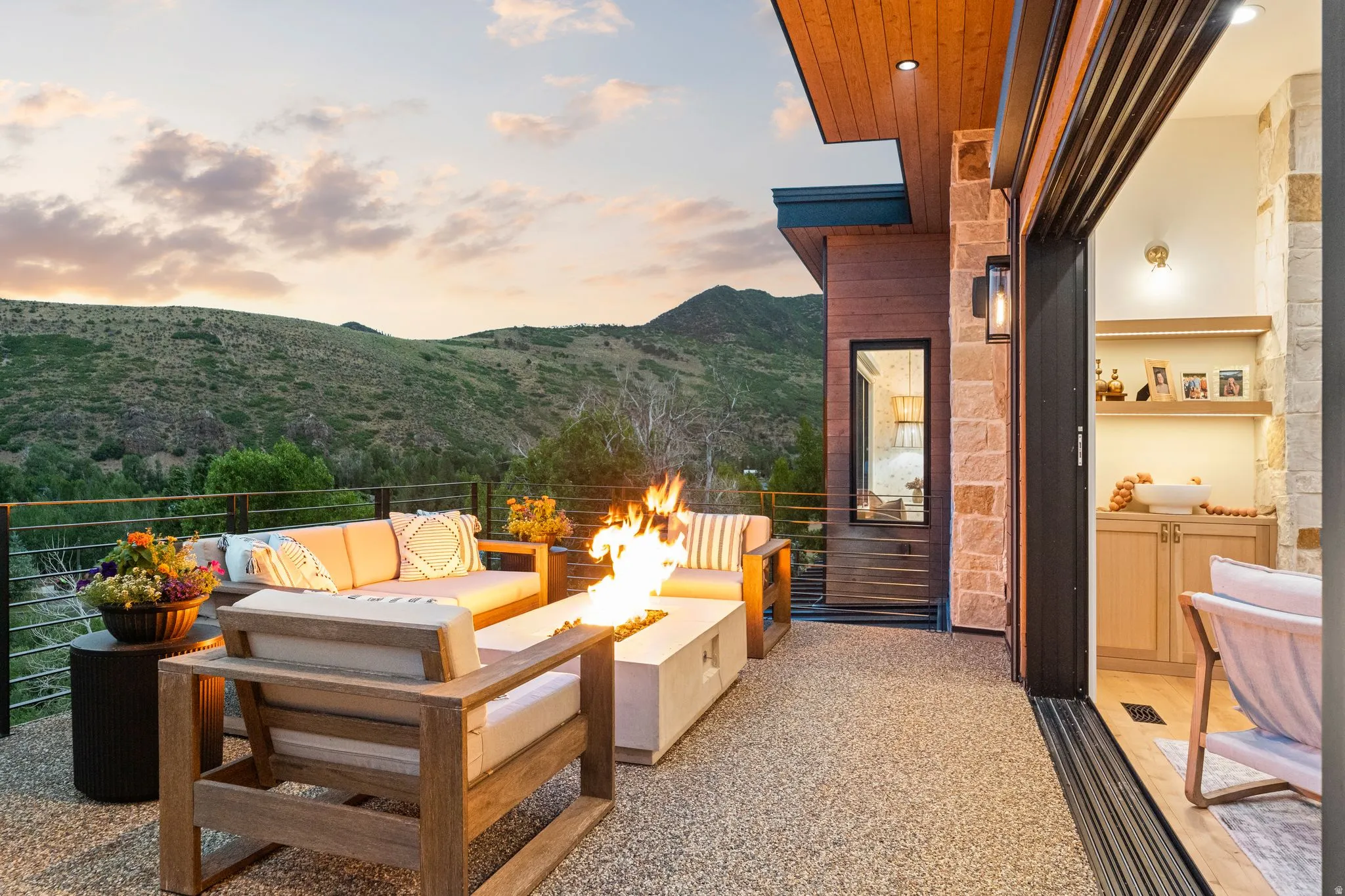 Outdoor living space featuring a concrete fire pit, stone accent wall, and a wood-paneled ceiling with recessed lighting