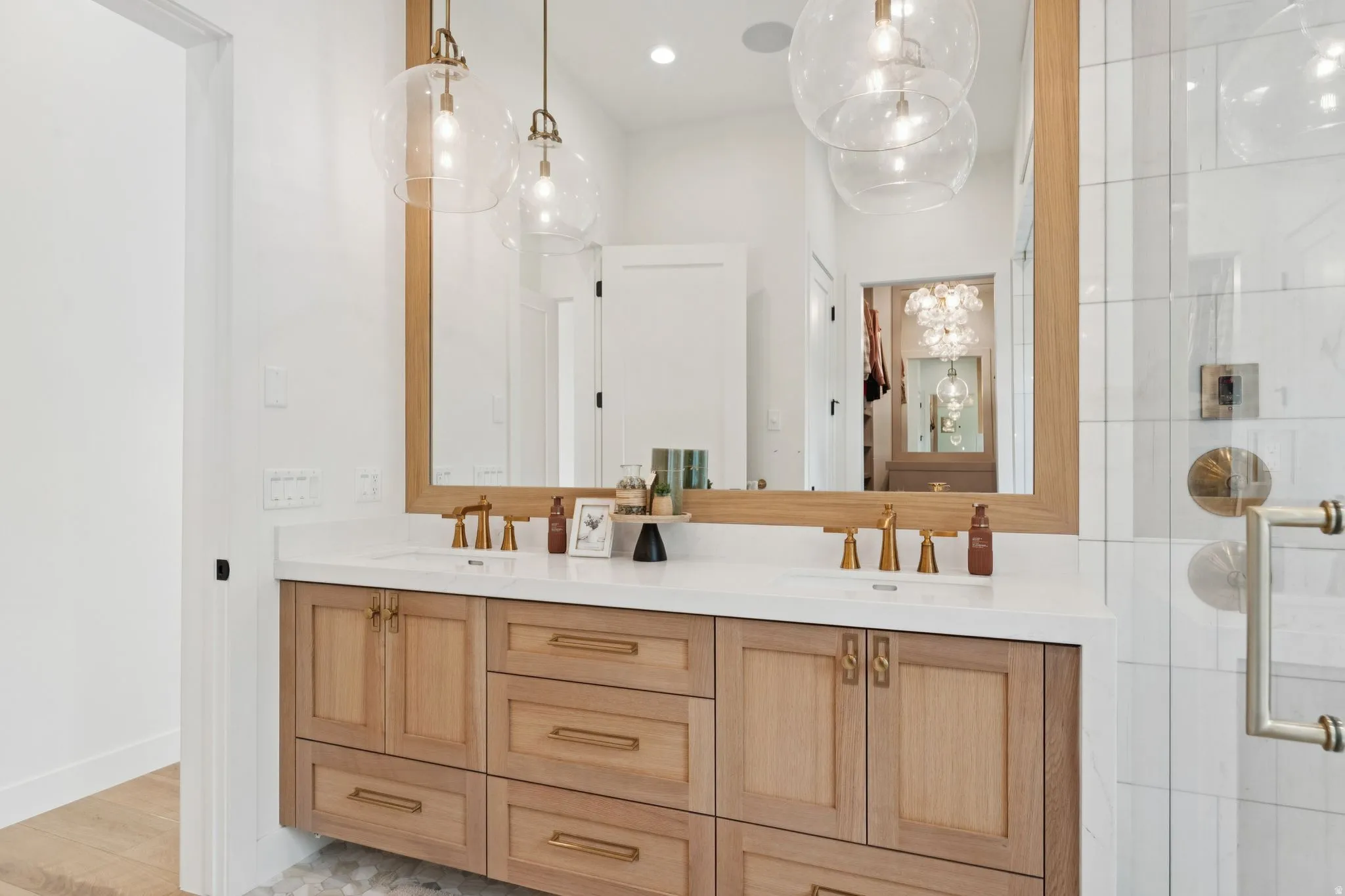 Double vanity featuring wood-finish cabinetry, white countertop, and brass fixtures