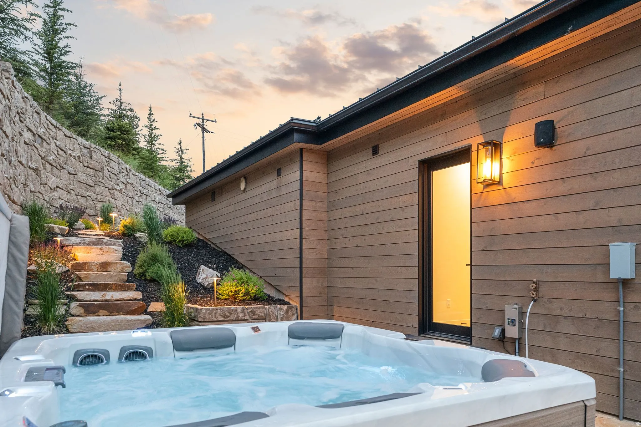 Outdoor spa with a stone staircase and integrated lighting