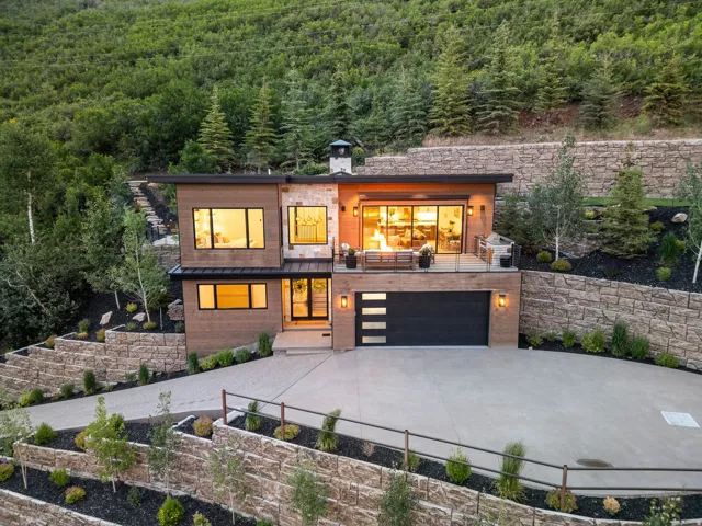 Modern architectural residence featuring wood-finish siding and stone accents