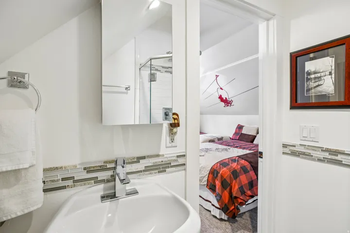 Compact bathroom featuring a white pedestal sink with a chrome faucet