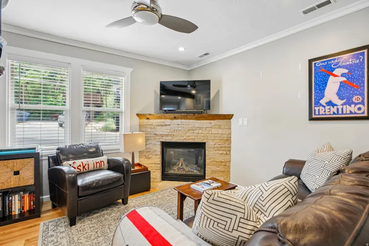 Corner gas fireplace with a stone surround and wood mantel