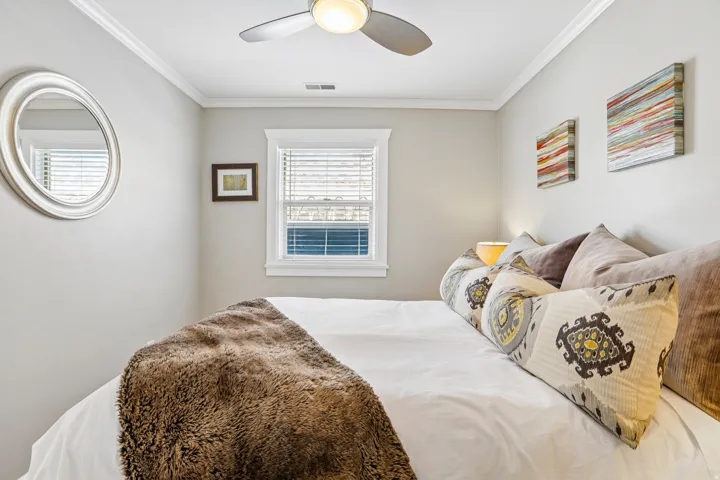 Neutral wall paint, crown molding, and a ceiling fan with integrated lighting