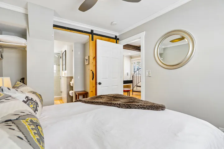 Bedroom featuring light gray walls, white crown molding, and a ceiling fan