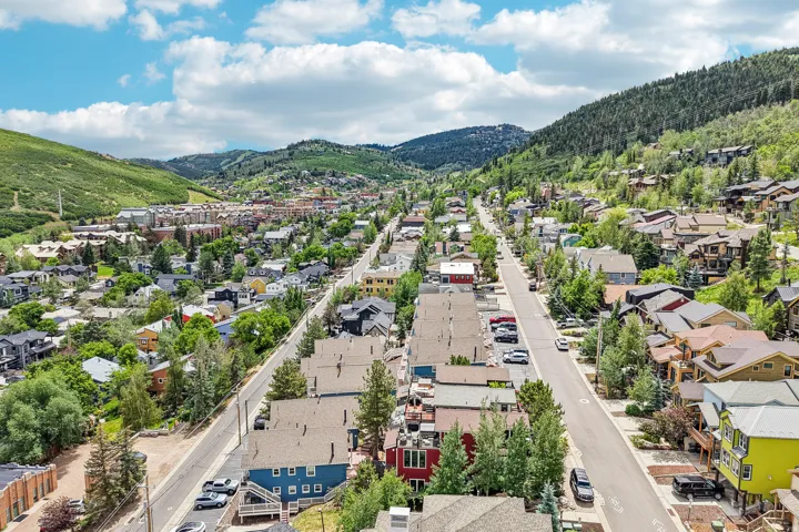 Aerial perspective showcasing a mountain town with a paved street flanked by residential properties