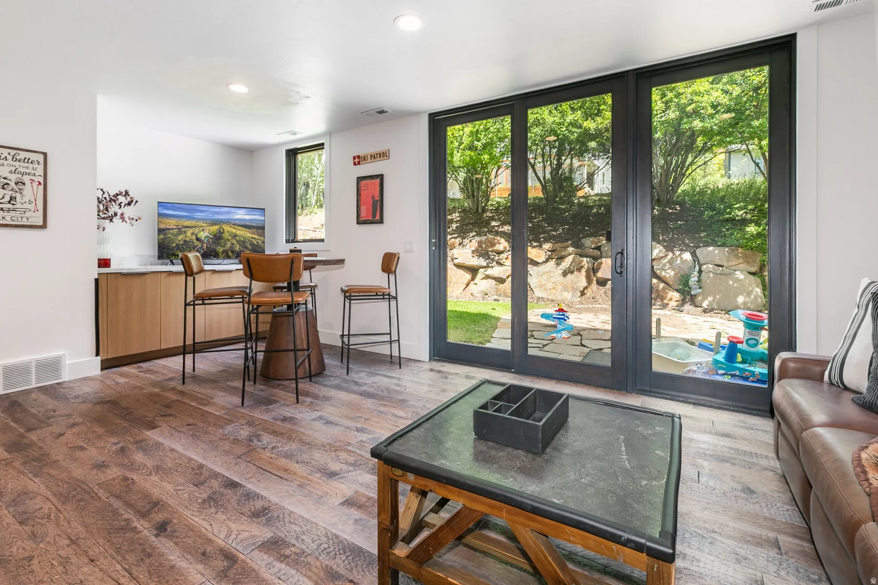 Spacious room featuring wood-finish flooring, recessed lighting, and a built-in cabinetry unit with a white countertop