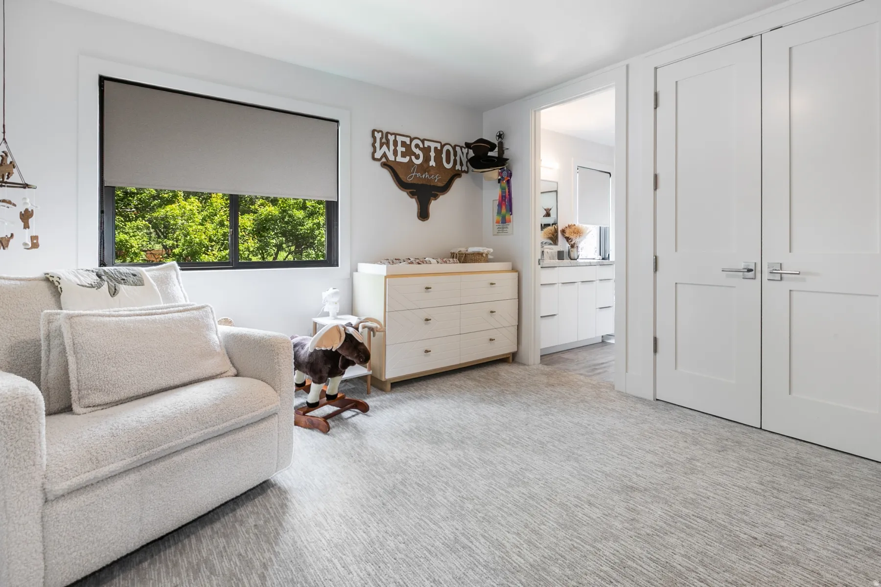 Light-toned wall-to-wall carpeting and bright white walls create a neutral palette