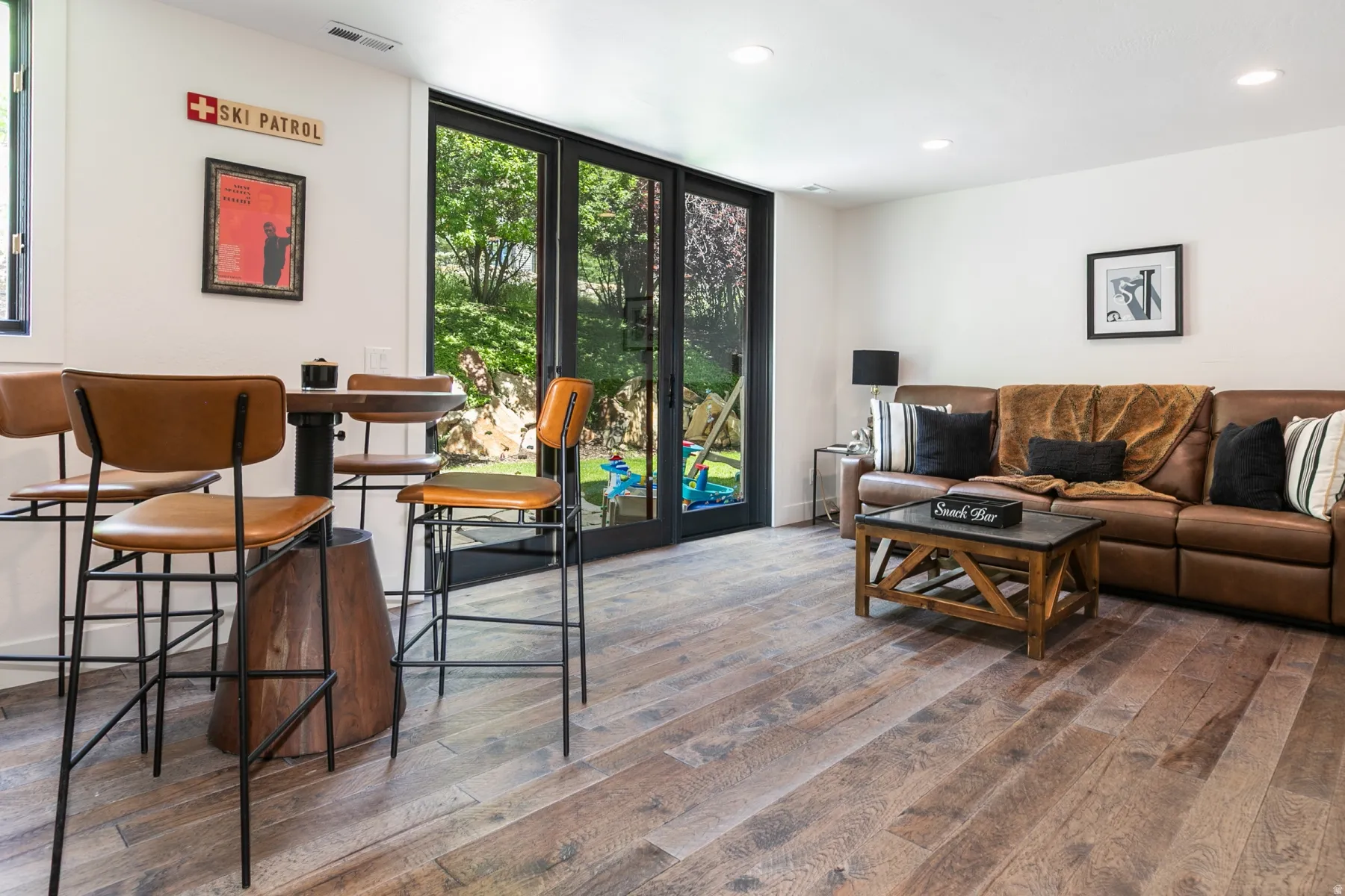 Spacious room featuring wide plank wood-finish flooring and extensive glass doors opening to the exterior