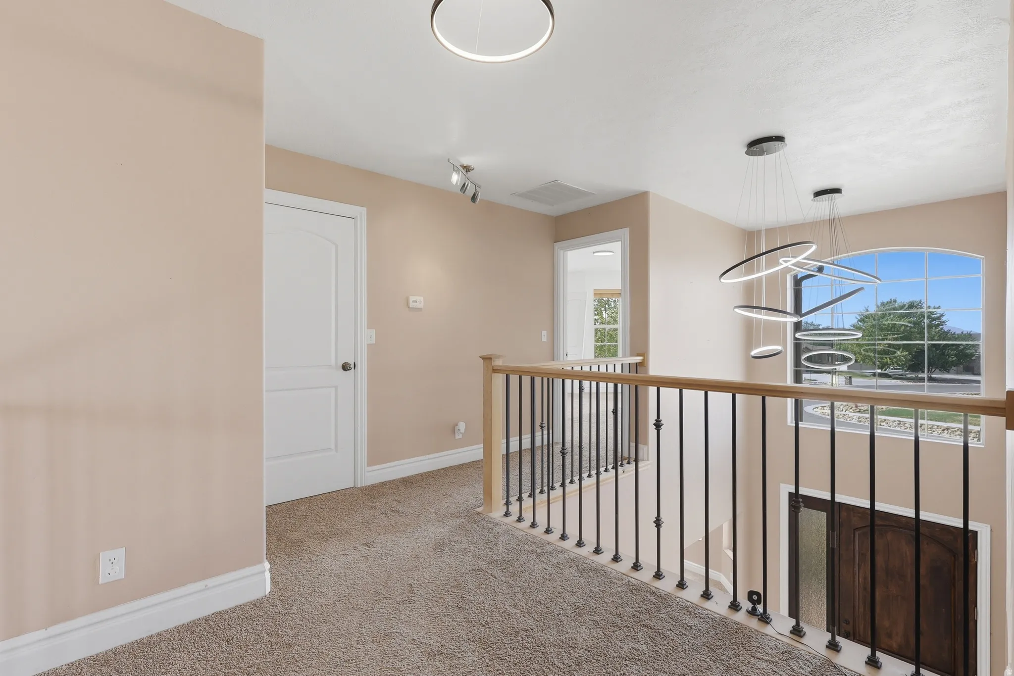 Open landing area featuring a wood-finish handrail with black metal spindles