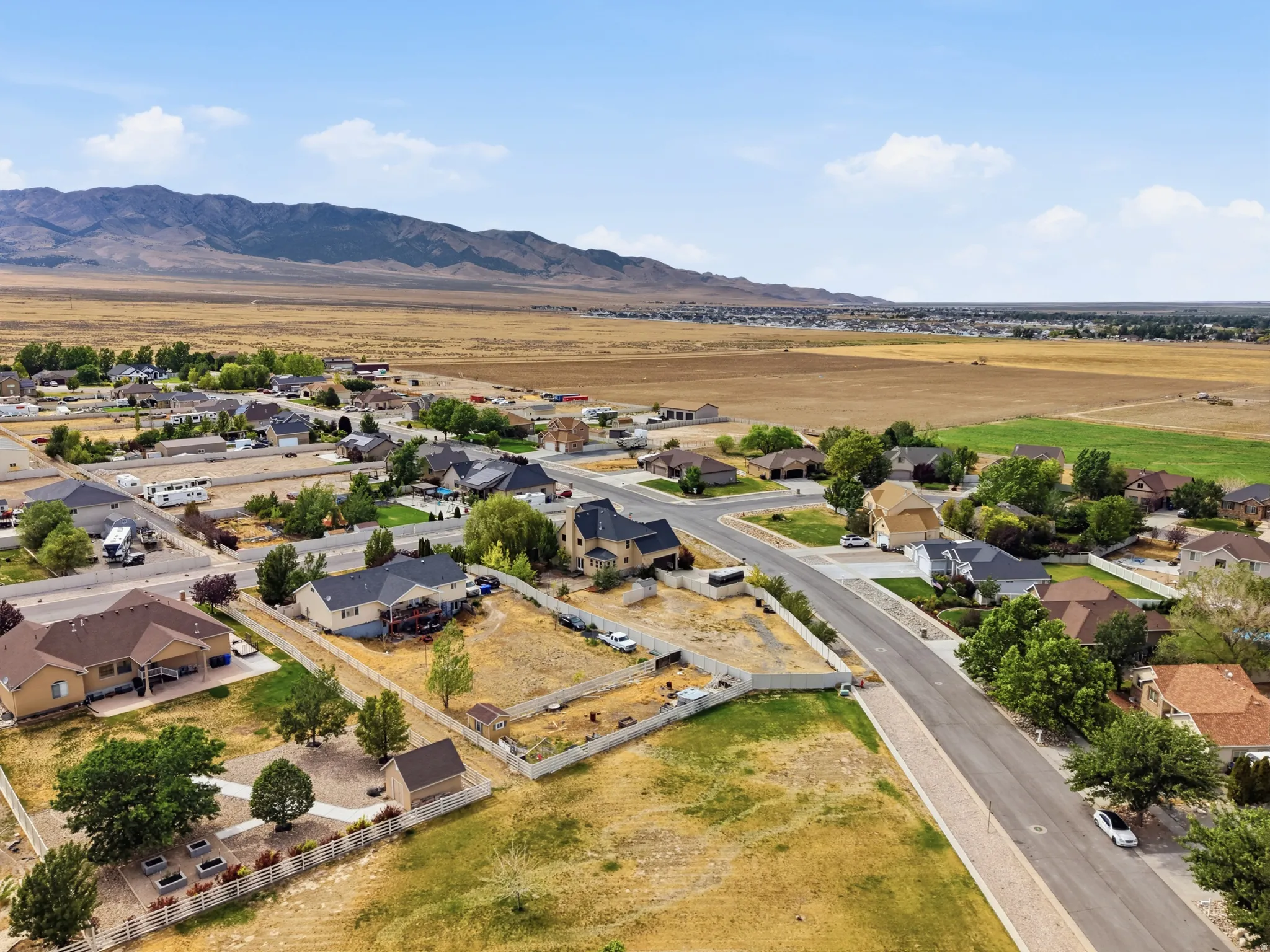 Aerial perspective showcasing a residential subdivision with scattered homes and undeveloped lots