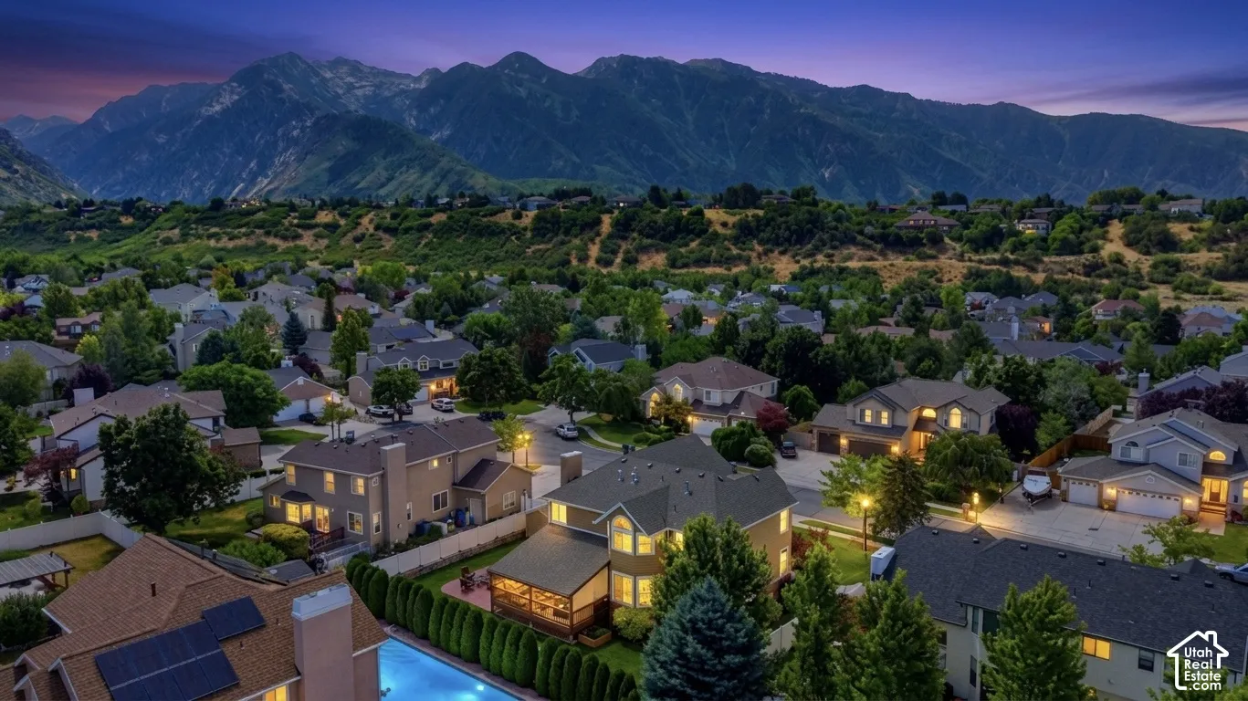 Expansive neighborhood setting with mature trees and mountain backdrop