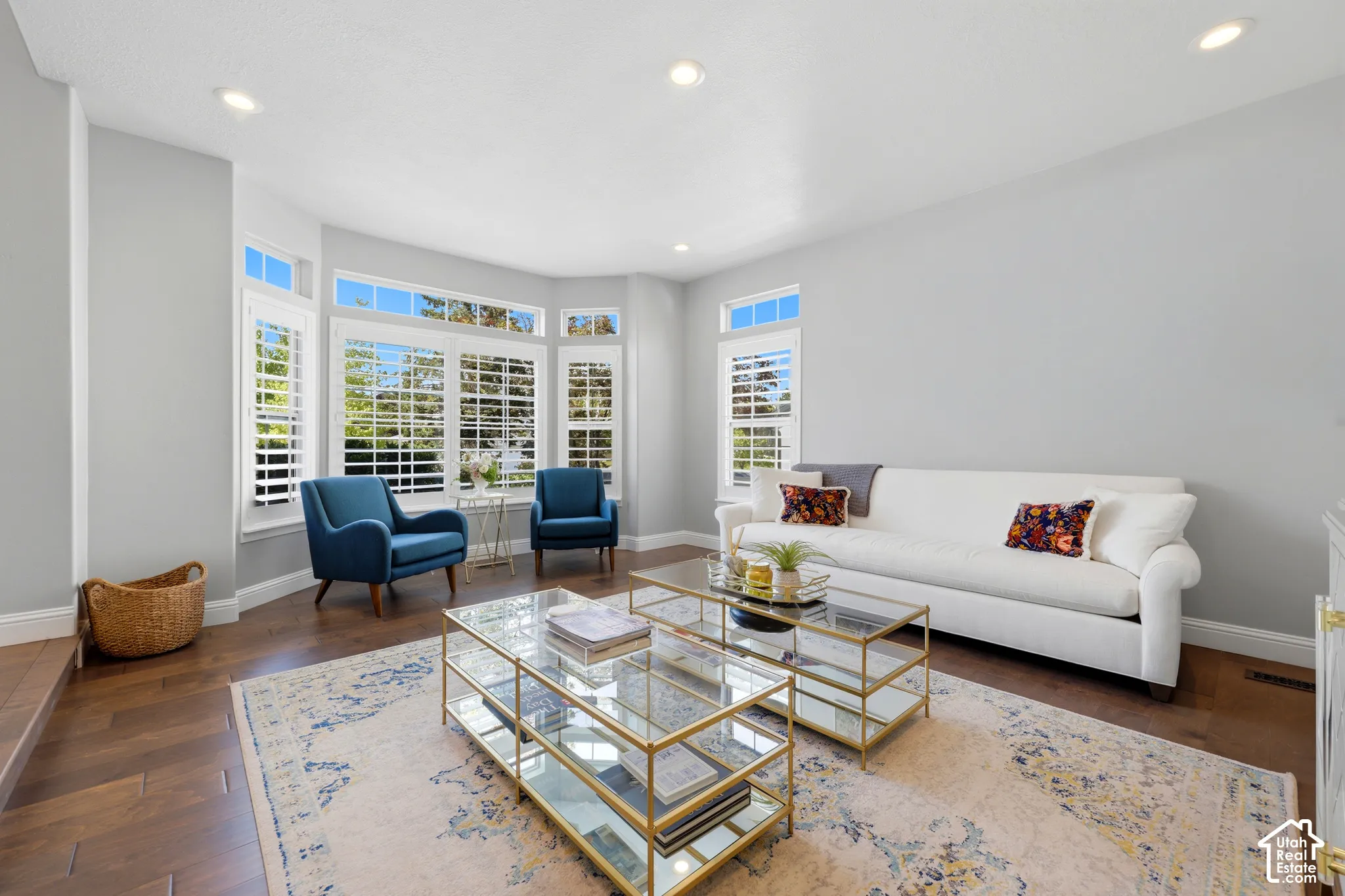 Spacious living area featuring bay windows with white plantation shutters