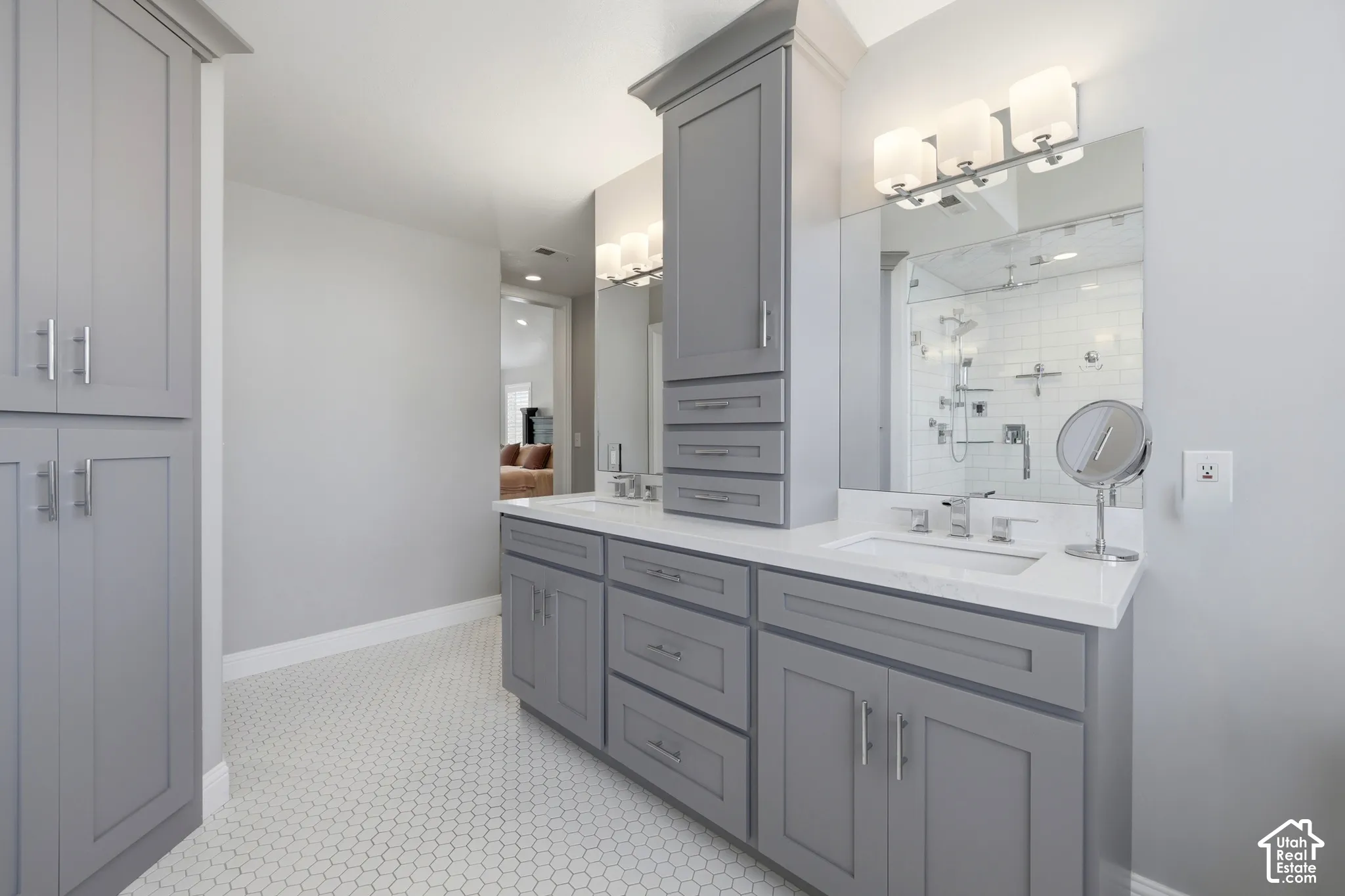 Bathroom featuring a dual vanity with light gray cabinetry and white countertops