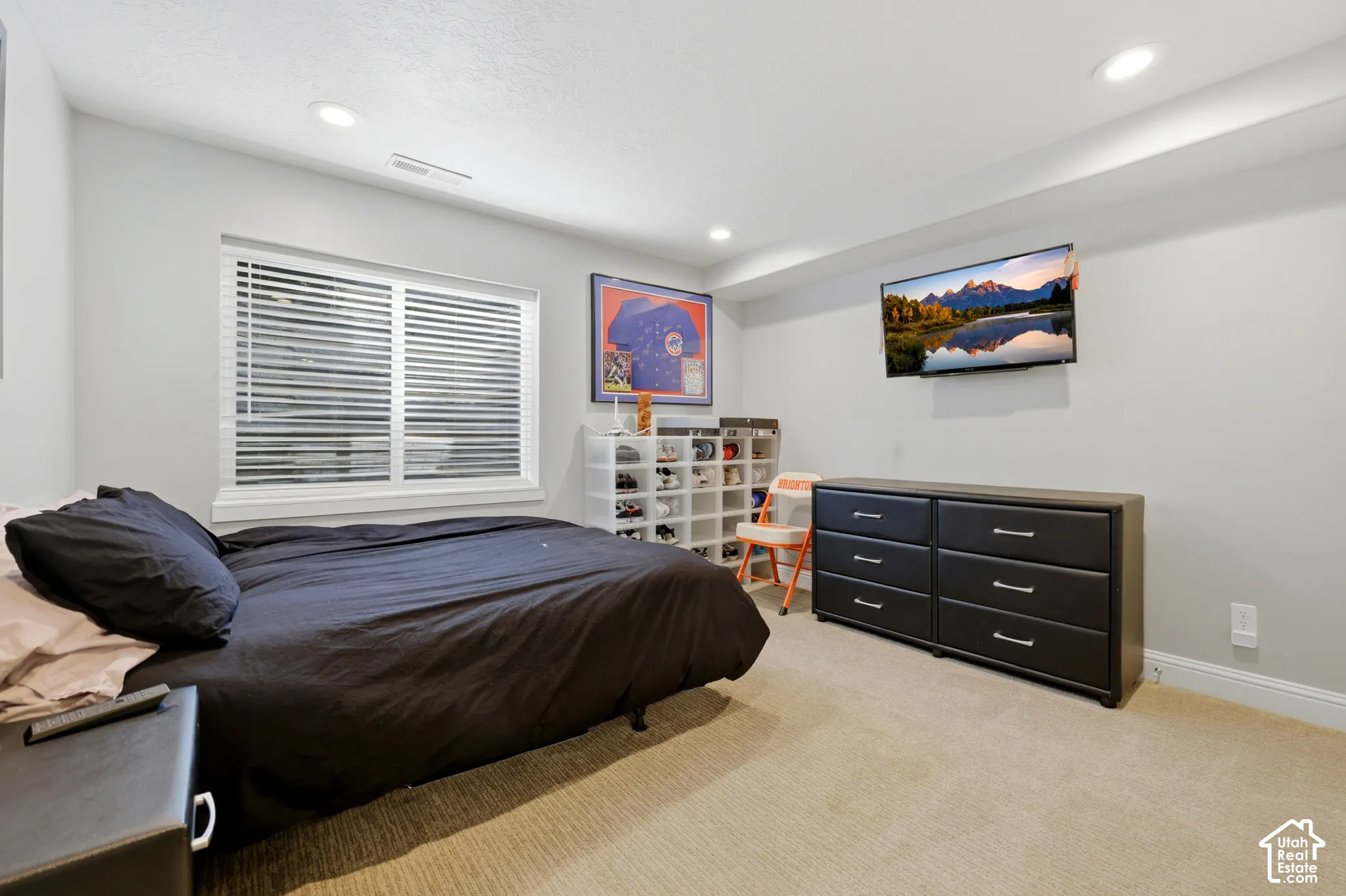 Bedroom featuring neutral carpeting, a large window with horizontal blinds, recessed lighting, and light gray wall paint