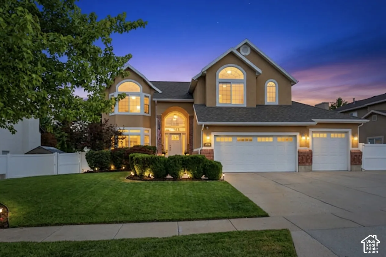 Two-story stucco residence featuring arched windows and an integrated two-car garage