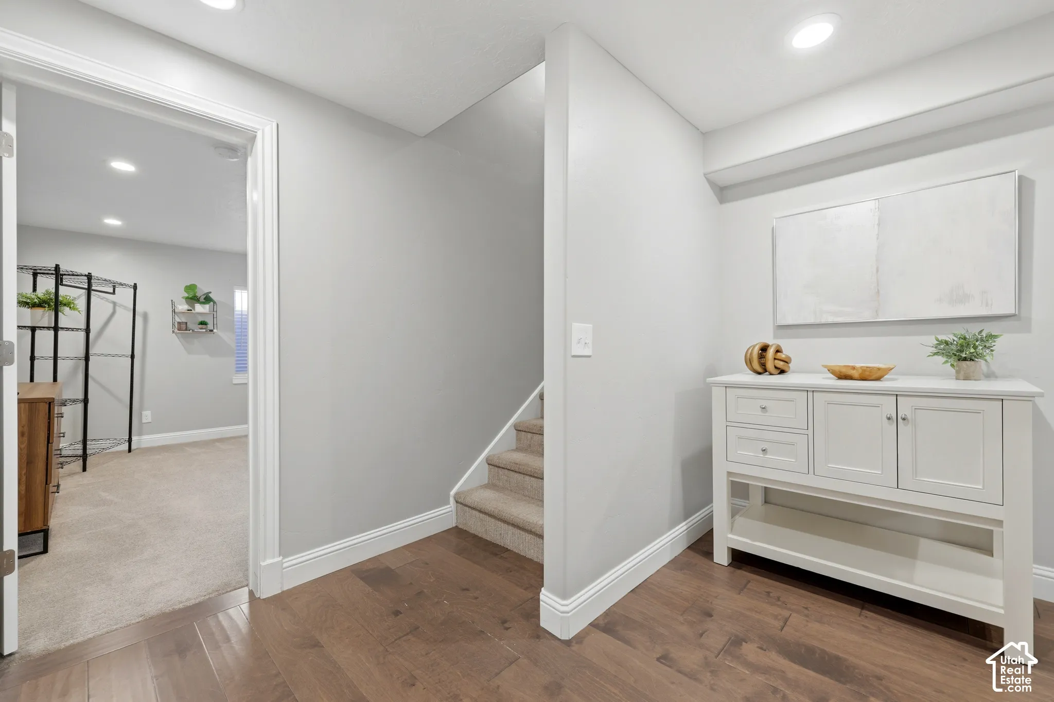 Wood-finish flooring throughout the main corridor, complemented by light gray wall tones and white baseboards