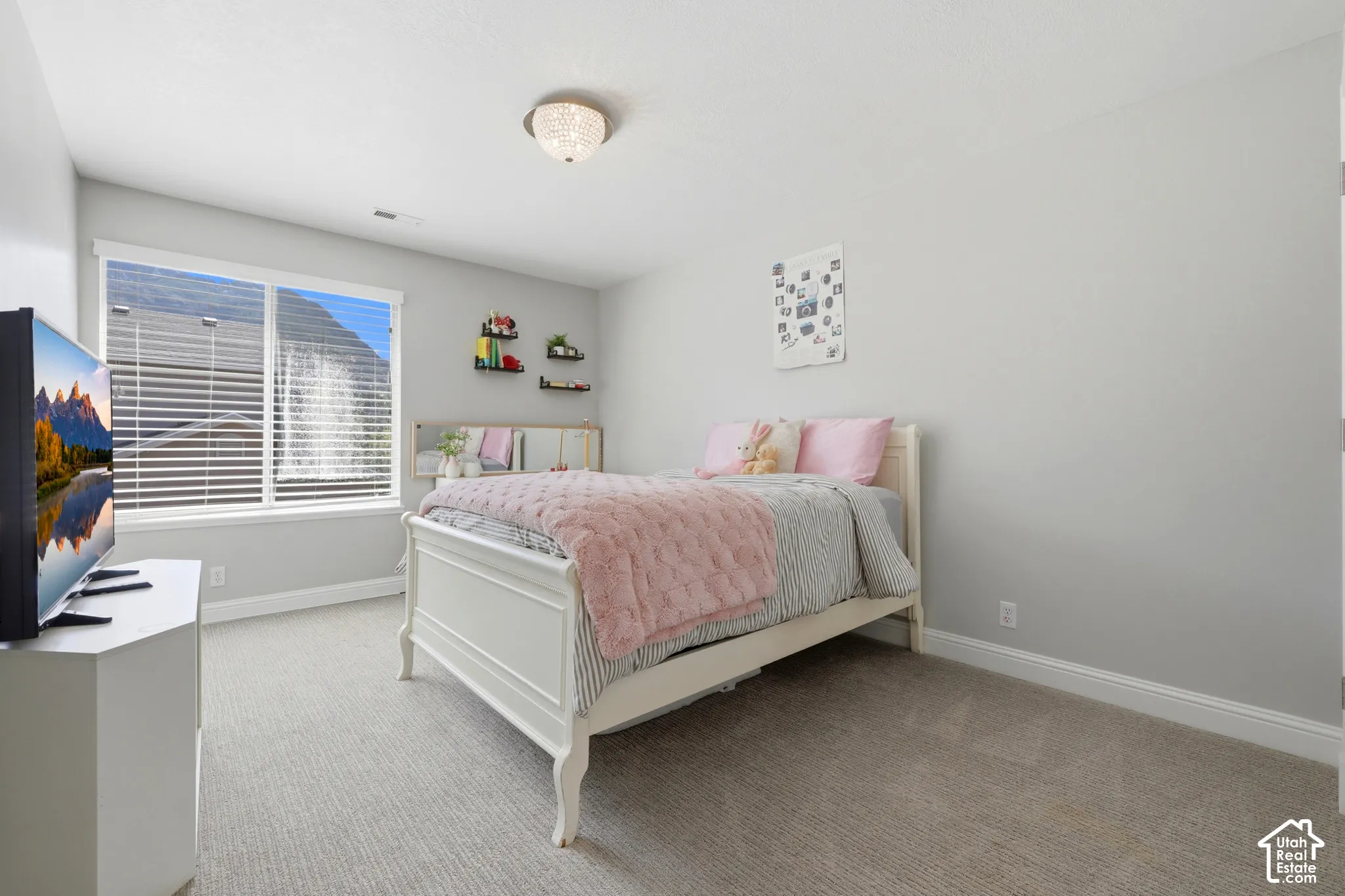 Room featuring light gray wall paint, light-colored carpet flooring, a large window with horizontal blinds, white baseboards, and a semi-flush mount ceiling light