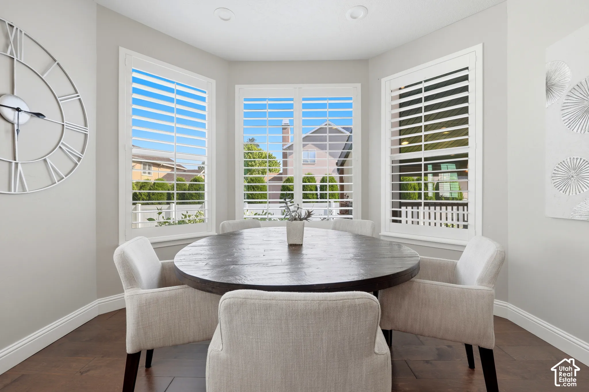 Bay window dining area featuring plantation shutters, recessed lighting, and wood-finish flooring
