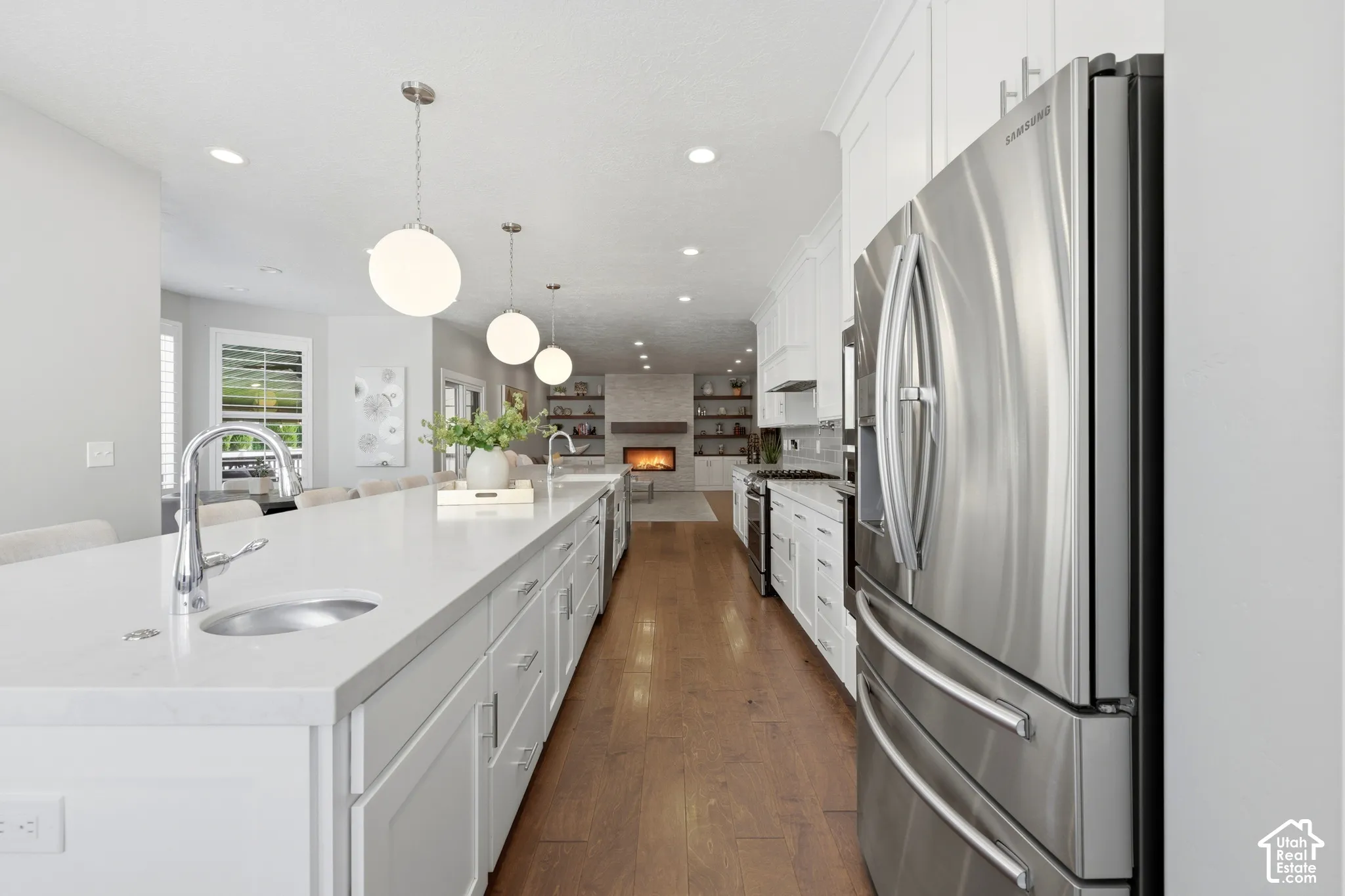 Open-concept kitchen with a large central island featuring an undermount sink and polished chrome faucet