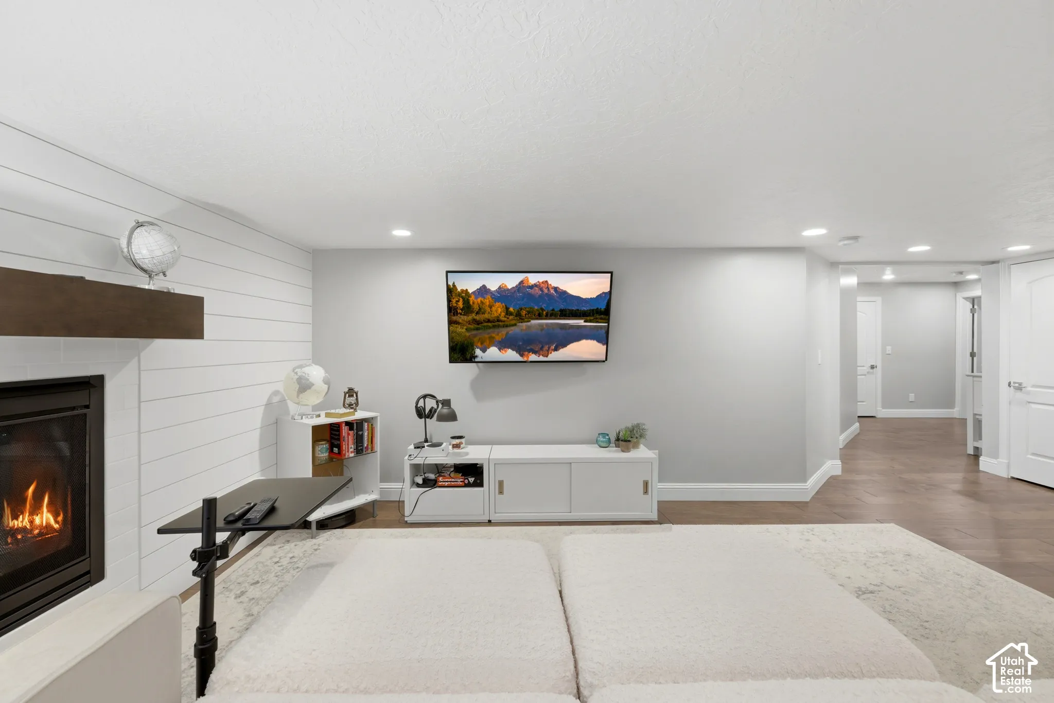 Living area featuring a fireplace with shiplap surround, wood mantel, mounted television, and recessed lighting