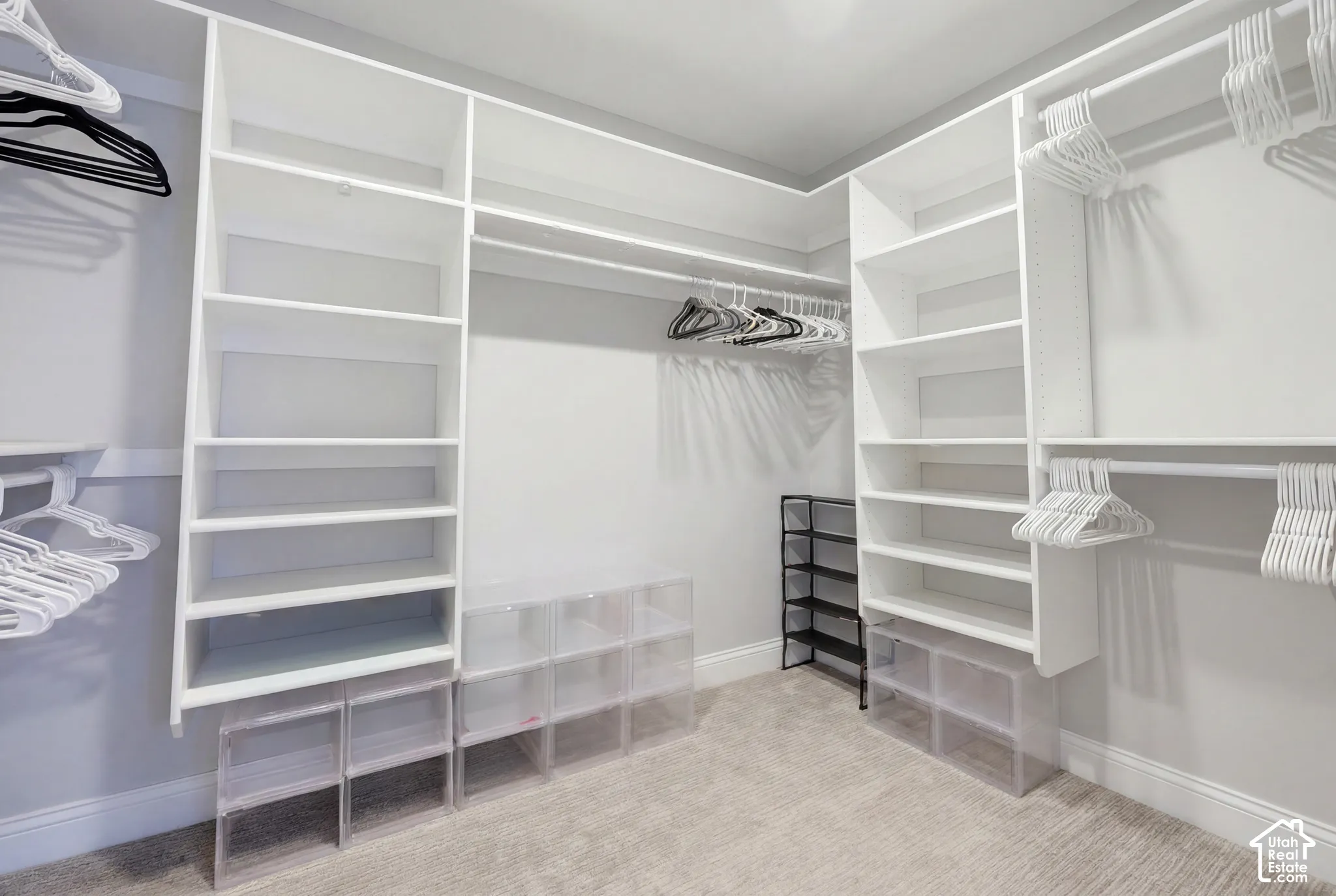 Custom-designed closet system featuring white shelving and multiple hanging rods for optimized storage