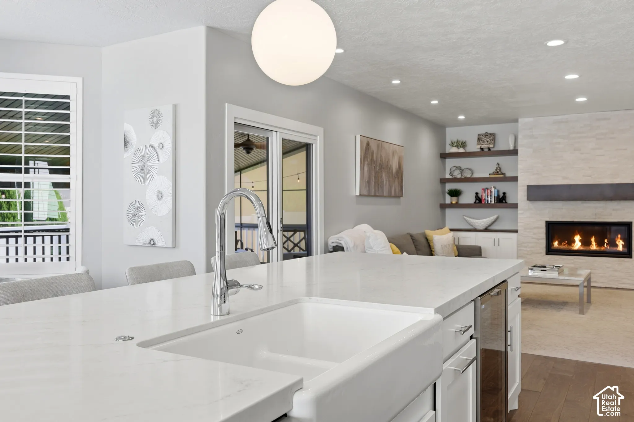 Kitchen island featuring a farmhouse sink and pull-down faucet