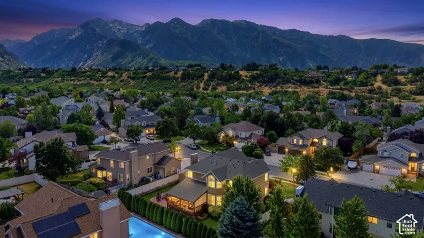 Expansive neighborhood setting with mature trees and mountain backdrop