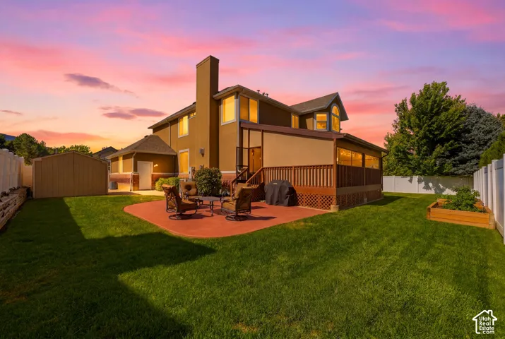 Spacious backyard with a large deck, concrete patio, and mature landscaping