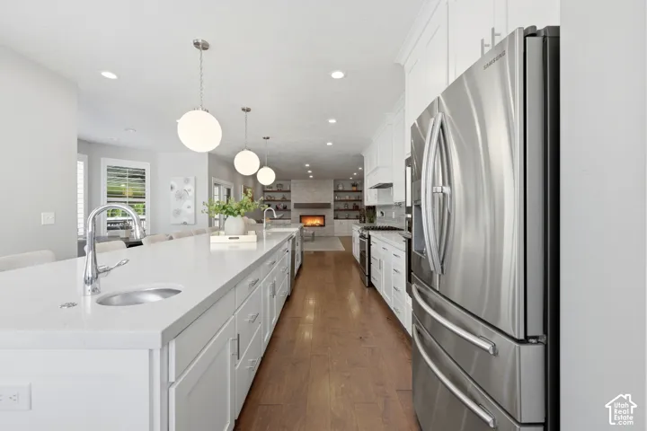 Open-concept kitchen with a large central island featuring an undermount sink and polished chrome faucet