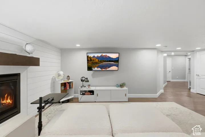 Living area featuring a fireplace with shiplap surround, wood mantel, mounted television, and recessed lighting