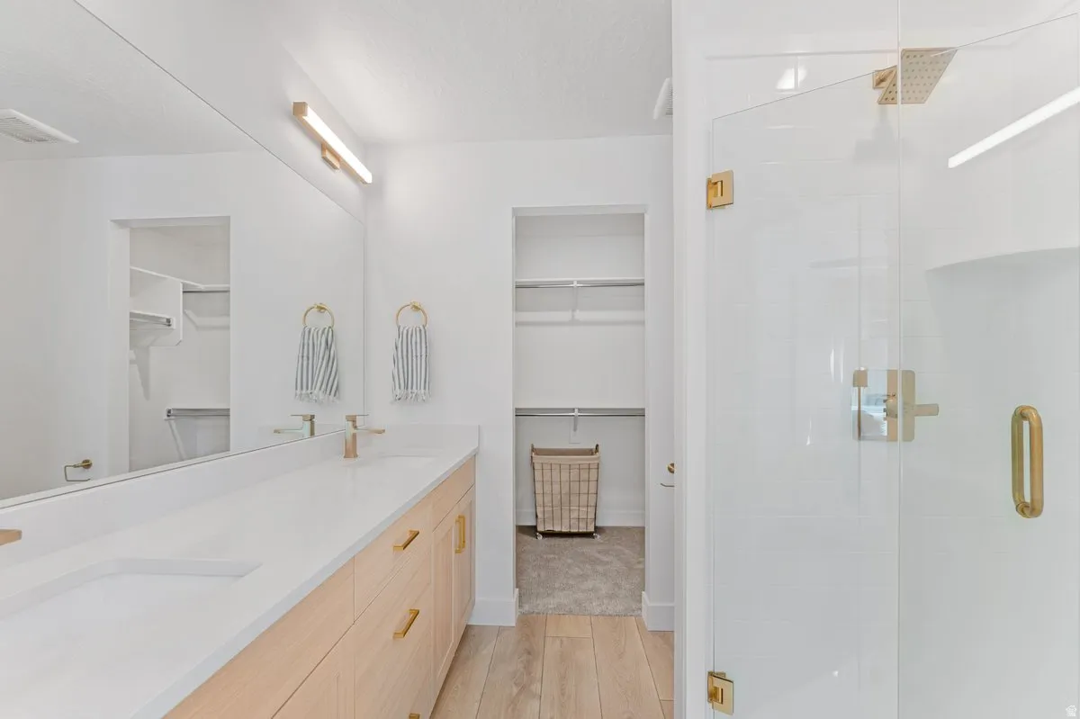 Bathroom featuring a dual vanity with light wood-finish cabinetry and a white countertop