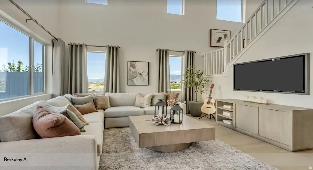 Vaulted living space featuring an open-tread staircase, a large picture window, and high transom windows. PICTURE IS OF A SIMILAR HOME