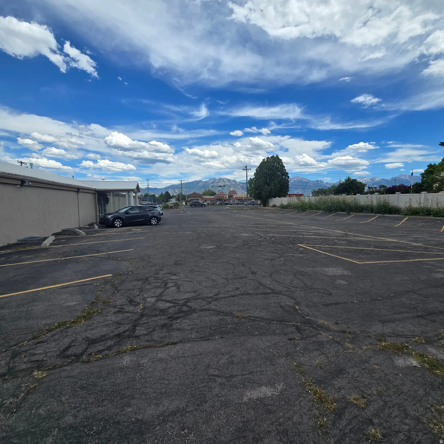 Expansive asphalt parking lot with painted parking spaces 40 stalls.