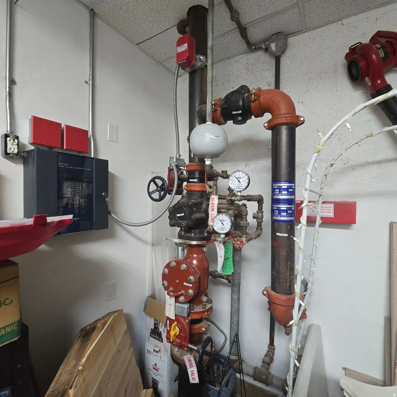 Commercial-grade sprinkler system featuring red pipes, pressure gauges, and control valves