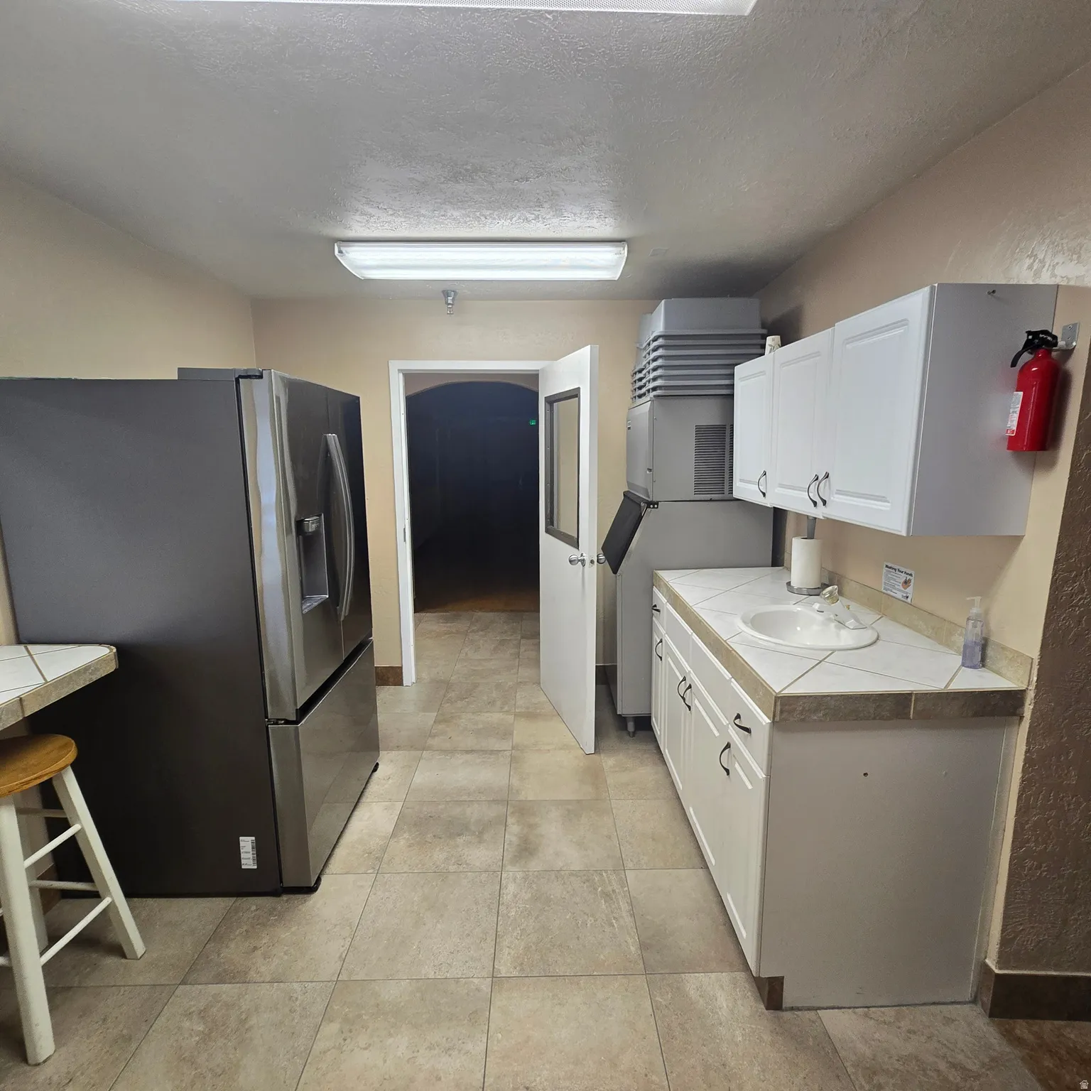 Functional kitchen space featuring tile flooring and neutral-toned walls