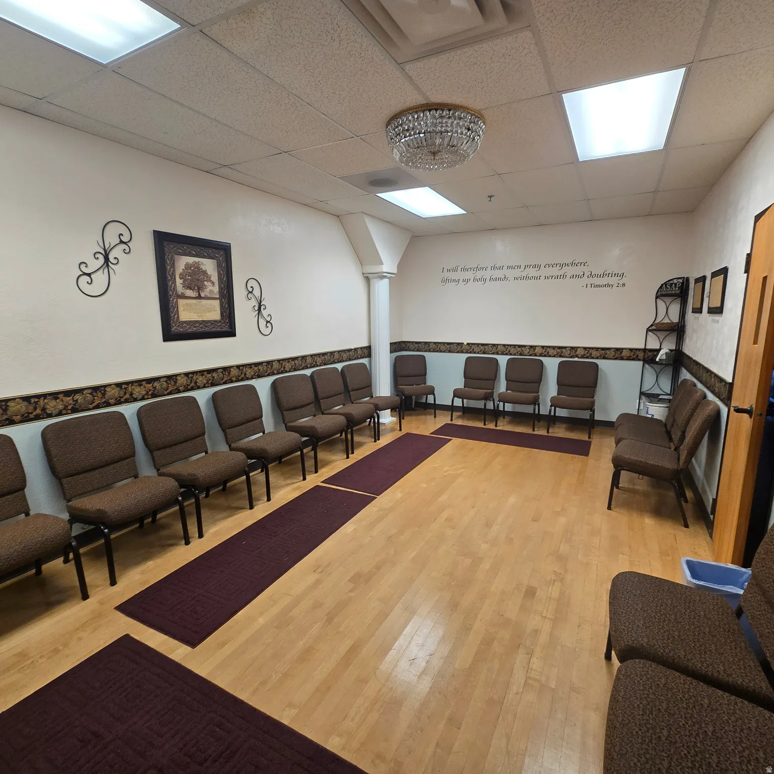 Spacious room featuring wood-finish flooring, recessed lighting, and a decorative chandelier