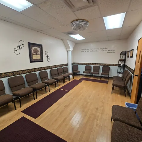 Spacious room featuring wood-finish flooring, recessed lighting, and a decorative chandelier