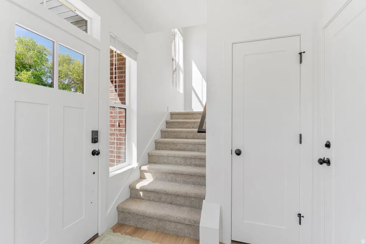 Entryway featuring a white paneled door with glass inserts, a smart lock, and matte black hardware